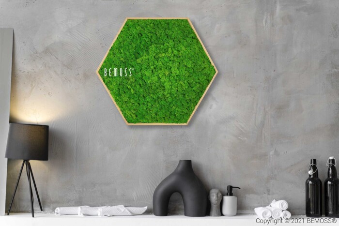 eine grüne Wand mit einem Holzrahmen und einer Vase mit Blumen darauf und einer Lampe daneben, moosbild, mooswand, moos pflanzen, moos, moos deko, moos art