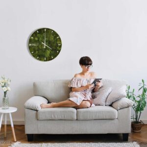 žena sediaca na gauči s knihou v ruke a hodinami na stene za ňou machovy obraz, stabilizovany mach, machová stena, machová dekorácia