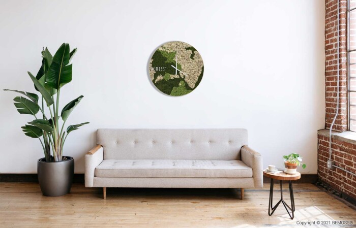ein Wohnzimmer mit einer Couch und einer Pflanze darin und einer Uhr an der Wand darüber, auf der die Uhrzeit steht, moosbild, mooswand, moos pflanzen, moos, moos deko, moos art